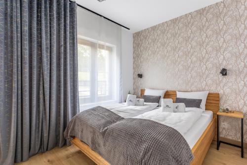 Un dormitorio con una cama grande y una ventana en Green Park Resort C5-z dostępem do basenu, sauny, jacuzzi, siłowni, en Szklarska Poręba
