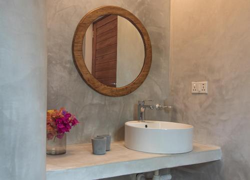 a bathroom with a white sink and a mirror at Pingwe Beach Apartments in Pingwe