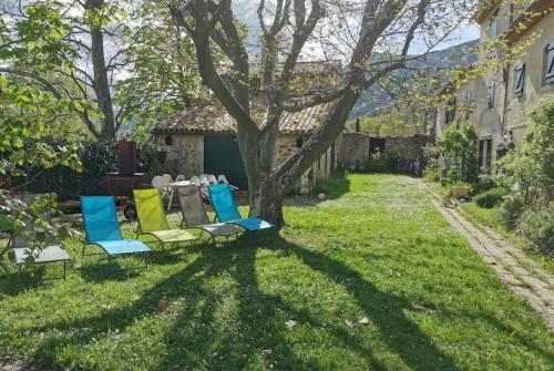 a group of chairs sitting on the grass in a yard at Véritable Mas Provençal À La Palud in La Palud sur Verdon