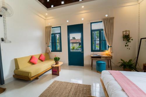 a bedroom with a bed and a couch and a table at Baan Pila in Luang Prabang