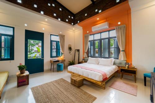ein Schlafzimmer mit einem Bett in einem Zimmer mit Fenstern in der Unterkunft Baan Pila in Luang Prabang