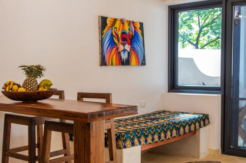 a dining room table with a bench and a painting at Pingwe Beach Apartments in Pingwe