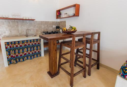 a kitchen with a wooden island with a bowl of fruit on it at Pingwe Beach Apartments in Pingwe