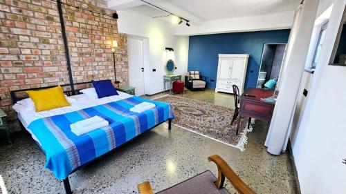 a bedroom with a bed and a brick wall at Alma Villa Guest House - Bosteri in Bosteri