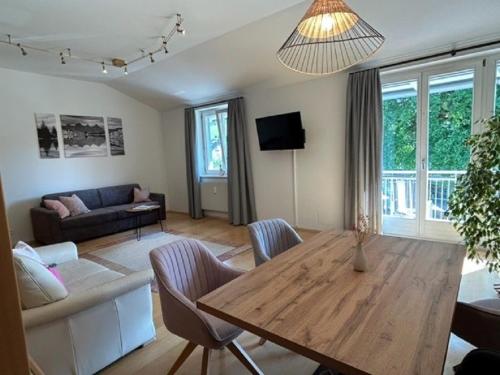 a living room with a wooden table and a couch at Haus Silent Apartment TOBI TOP 27 in Schladming