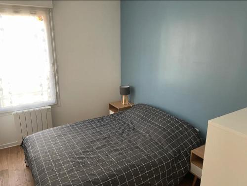 une chambre avec un lit et une fenêtre dans l'établissement Appartement 2 chambres - 50m de la mer - parking, à Lion-sur-Mer