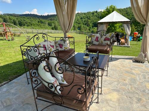 a table and chairs with a playground in the background at Casa Bradet in Întorsura Buzăului