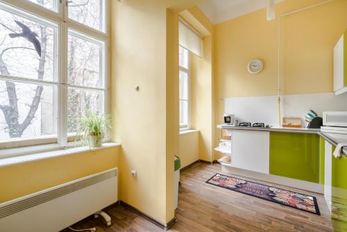 a kitchen with yellow and green walls and windows at Pyvo Street Home with balcony near the Danube in Budapest
