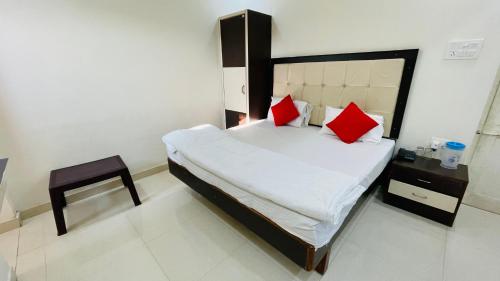 a bedroom with a large bed with red pillows at Hotel Prabhat Palace in Kota
