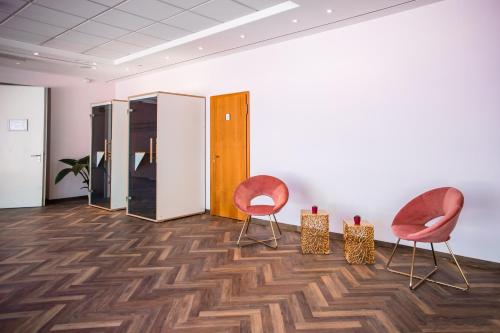 two chairs in an empty room with wooden floors at Müggelseeperle in Berlin