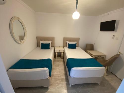 two beds in a small room with a mirror at Otantik Shumen in Shumen