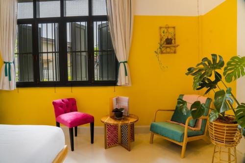 a bedroom with a bed and two chairs and a table at Baan Pila in Luang Prabang