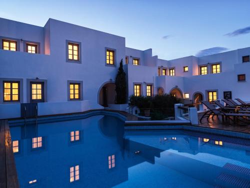 uma villa com piscina em frente a um edifício em The Petra em Patmos