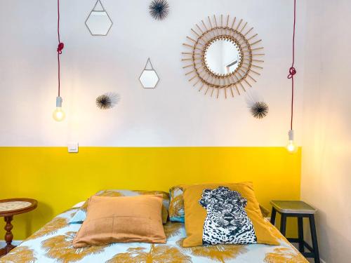 een slaapkamer met een gele en witte muur en een bed bij Ilbarritz, T2 proche plage/parking/terrasse in Bidart
