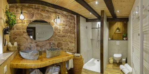 La salle de bains est pourvue de 2 lavabos et d'un mur en pierre. dans l'établissement Gîte Bien-être, Sauna, Bain nordique à Soucht (57), à Soucht