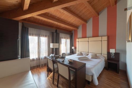 a bedroom with a bed and a desk in a room at Albergo Minuetto in Adria