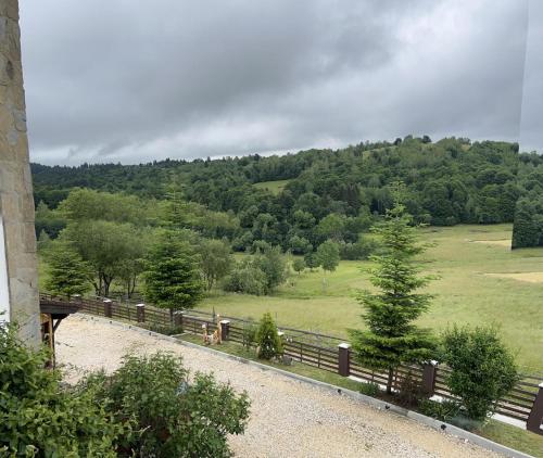 a fence with a field and trees in the background at Casa Bradet in Întorsura Buzăului