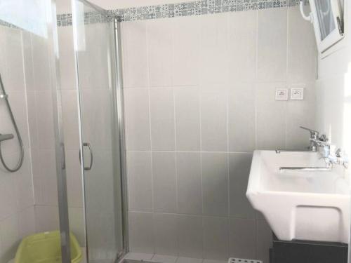 W łazience znajduje się prysznic i umywalka. w obiekcie Loft avec jardin au bord de l'eau au rdc d'une ancienne école w mieście Plougastel-Daoulas