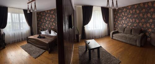 a living room with a couch and a chair and a table at Casa Bradet in Întorsura Buzăului