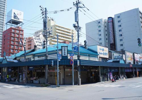 a building with a blue roof on a city street at Tokyu Stay Sapporo Odori in Sapporo