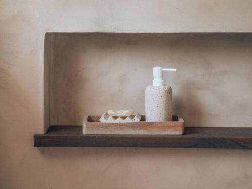 a shelf with a bottle of soap and a toothbrush at Umdloti Boho Beach Villa in Umdloti