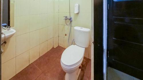 uma casa de banho com um WC branco e um lavatório. em Wisma Malawen Mitra RedDoorz em Palangkaraya