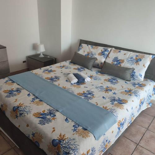 uma cama com um cobertor e almofadas em Attico Centrale Ostia 20 em Lido di Ostia