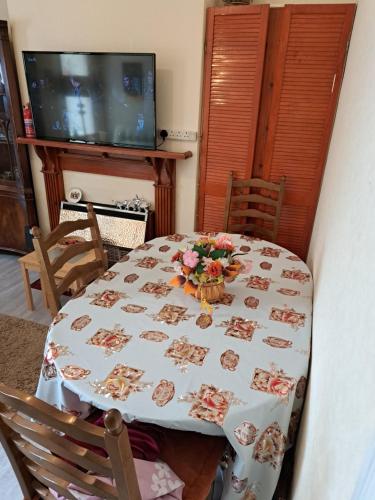 uma mesa com uma toalha de mesa com flores em Luxury double bedroom London Seven Kings Train station em Londres