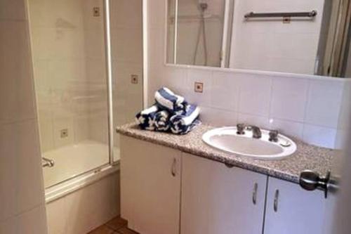 uma casa de banho com um lavatório, um chuveiro e uma banheira em 2 Bedroom Ocean View - Alexandria Apartments -Alexandra Headland em Maroochydore