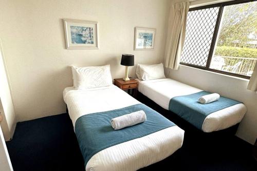 um quarto com duas camas e uma janela em 2 Bedroom Ocean View - Alexandria Apartments -Alexandra Headland em Maroochydore