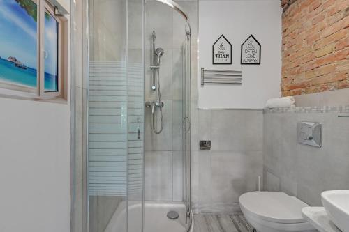 a bathroom with a shower and a toilet and a sink at Amber Baltic 2 by Grand Apartments in Gdynia