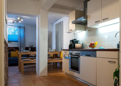 uma cozinha com armários brancos e uma sala de jantar em Spacious Apartment in urban location em Hamburgo