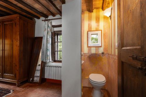 a bathroom with a toilet and a window at Casale Mulin Bianco in Monteriggioni
