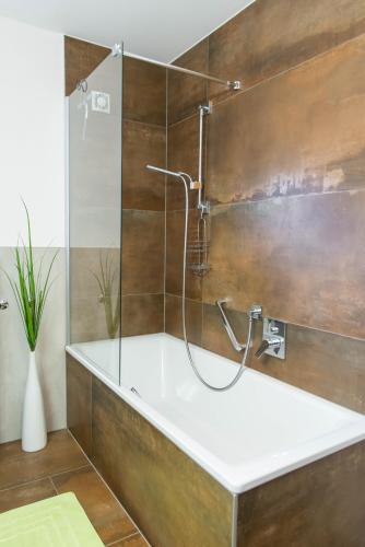 Un baño con bañera y ducha. en Appartements Gadenstätter, en Maria Alm am Steinernen Meer