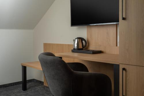 a room with a desk with a chair and a television at Pivovar Rožmberk in Rožmberk nad Vltavou