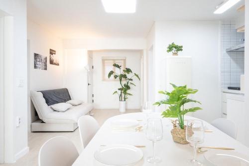 a white living room with a white table and chairs at Le Cocon Seoul in Seoul