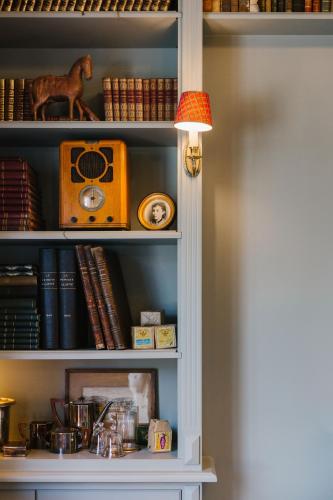 a book shelf with a radio and books at La Maison d’Hôtes in Silly