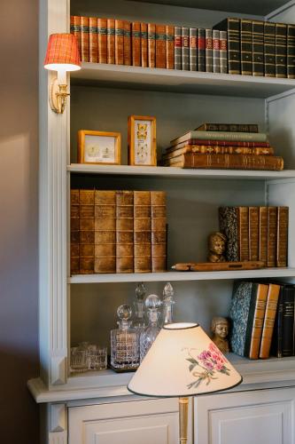 a lamp sitting on a shelf with books at La Maison d’Hôtes in Silly