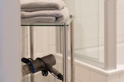 einen Handtuchhalter mit einem Haartrockner und Handtüchern in der Unterkunft Ferienwohnung Baden Baden in Baden-Baden