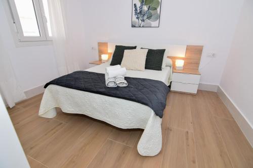 sypialnia z dużym łóżkiem z dwoma butami w obiekcie Apartamentos Atlantida w mieście Chipiona