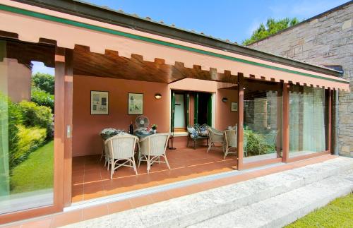 索亞諾德拉戈的住宿－Villetta Golf Holidays，一个带玻璃门和桌椅的庭院