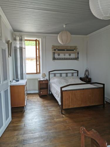 une chambre avec un lit et un parquet dans l'établissement L Oustal du Malbernat, à Frayssinet-le-Gélat