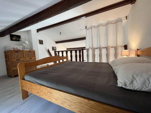 ein Schlafzimmer mit einem großen Bett mit einem Holzrahmen in der Unterkunft Villa Saint-Cyprien, 2 pièces, 6 personnes - FR-1-106-88 in Saint-Cyprien