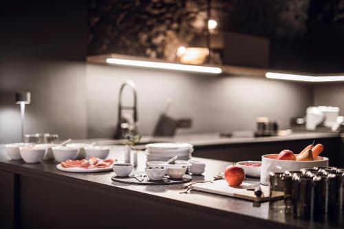 a kitchen counter with plates and bowls of food at Rousa little guesthouse Cosy Sky in Rasun di Sopra