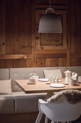 a table and a couch in a living room at Rousa little guesthouse Cosy Sky in Rasun di Sopra