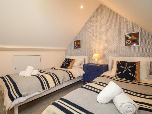 um quarto com 2 camas e uma parede azul em Blanche Cottage em Weymouth