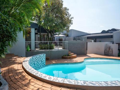 a swimming pool in front of a house at Casa Albergo Corporate Guest House in Pretoria