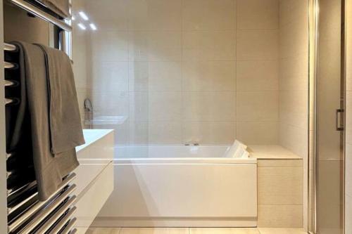 La salle de bains est pourvue d'une baignoire blanche et d'une douche. dans l'établissement Exclusive Resort Saint-Tropez, à Saint-Tropez