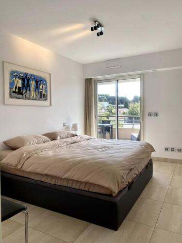 une chambre avec un grand lit et une grande fenêtre dans l'établissement Exclusive Resort Saint-Tropez, à Saint-Tropez