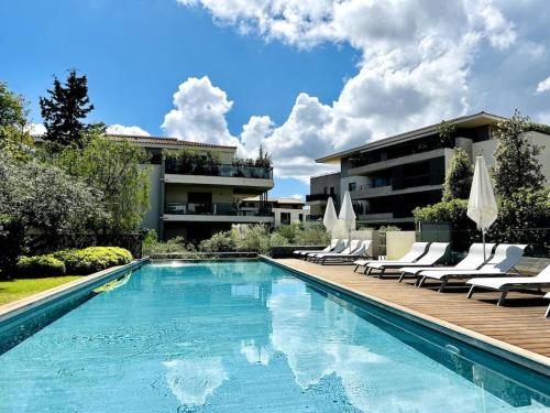 een zwembad met ligstoelen en een gebouw bij Exclusive Resort Saint-Tropez in Saint-Tropez